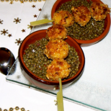 Warm lentils with raspberry vinegar and white pudding skewers breaded in pine nuts