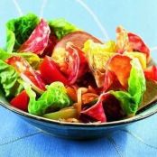 Caesar salad with potatoes, salami and chitterlings